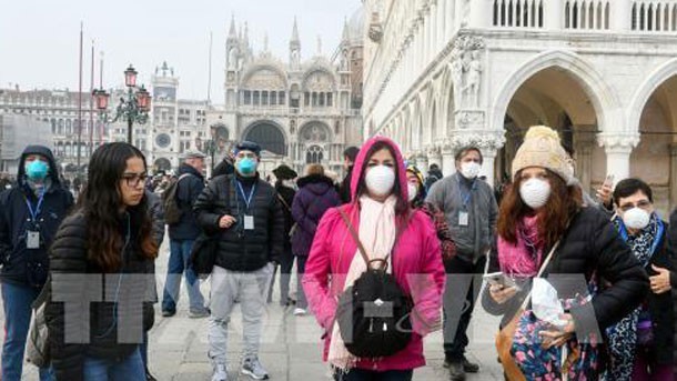 Khách du lịch đeo khẩu trang phòng dịch Covid-19 tại Venice, Italy ngày 25/2. Ảnh: AFP/TTXVN.