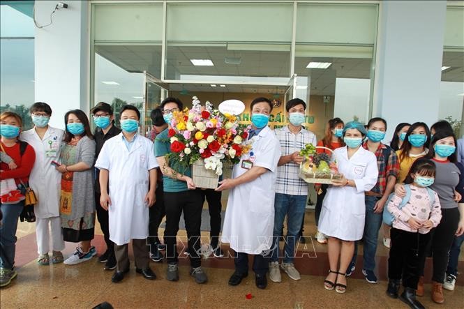 Cán bộ, bác sỹ bệnh viện Nhiệt đới Trung ương tặng hoa chúc mừng 30 người trở về từ Vũ Hán (Trung Quốc) hoàn thành thời gian cách ly, ngày 2/3/2020. Ảnh: Minh Quyết/TTXVN