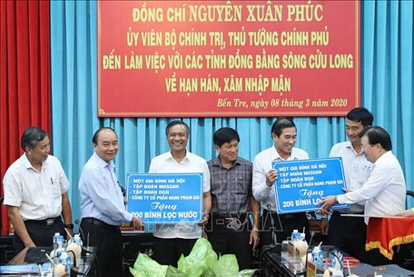 Thủ tướng Nguyễn Xuân Phúc và Phó Thủ tướng Trịnh Đình Dũng trao tặng bình lọc nước cho 8 tỉnh Đồng bằng sông Cửu Long, mỗi tỉnh 200 bình do các Tổ chức và cá nhân tài trợ. Ảnh: Thống Nhất/TTXVN