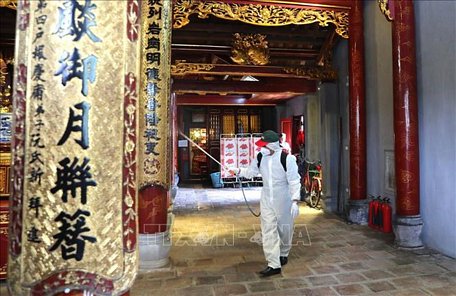  Nhân viên Sở y tế Hà Nội phun thuốc tiêu độc khử trùng bên trong đền Bà Kiệu. Ảnh: Thành Đạt/TTXVN