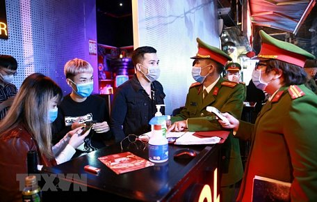 Lực lượng Công an quận Hoàn Kiếm kiểm tra thiết bị đo thân nhiệt tại vũ trường The Bunker, nơi tập trung đông người tại phố Mã Mây, quận Hoàn Kiếm. (Ảnh: Doãn Tấn/TTXVN)