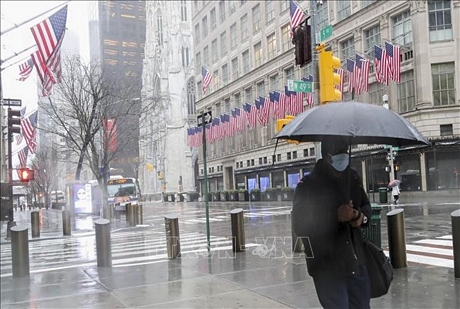 Người dân đeo khẩu trang để phòng tránh lây nhiễm COVID-19 tại New York, Mỹ, ngày 23/3. Ảnh: THX/TTXVN