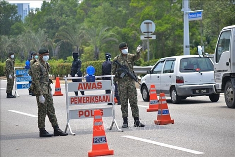 Binh sĩ Malaysia làm nhiệm vụ tại một chốt chặn trong thời gian thực thi lệnh phong tỏa nhằm ngăn dịch COVID-19 lây lan, ở Putrajaya ngày 22/3/2020. Ảnh: THX/TTXVN