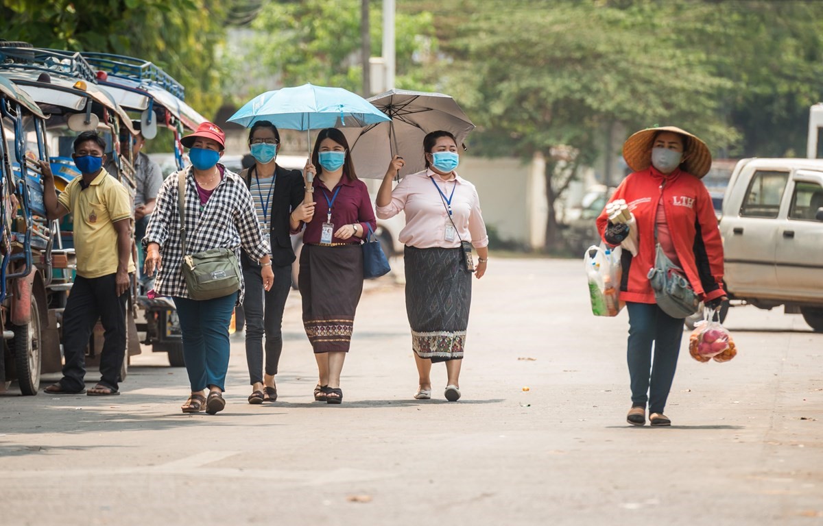 Người dân đeo khẩu trang nhằm ngăn chặn sự lây lan của dịch COVID-19 tại thủ đô Vientiane, Lào ngày 23/3/2020. (Ảnh: THX/TTXVN)
