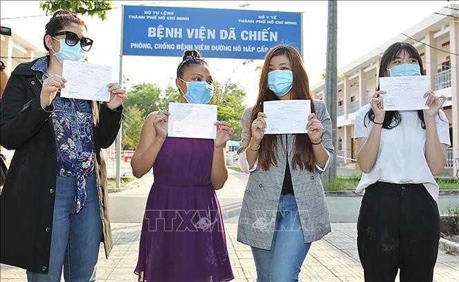 Bệnh nhân vui mừng khoe giấy chứng nhận ra viện xuất viện. Ảnh: Đinh Hằng/TTXVN