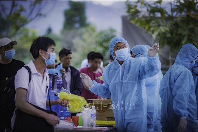 Các công dân được lực lượng chức năng hướng dẫn về khu cách ly nhận phòng tại Trường Quân sự tỉnh Hòa Bình. Ảnh Trọng Đạt/TTXVN
