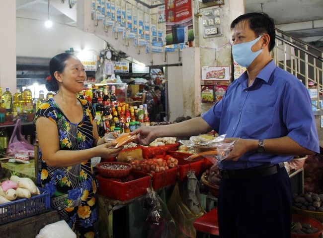 Ban Quản lý chợ nhắc nhở và phát khẩu trang cho các tiểu thương chưa đeo khẩu trang theo quy định.