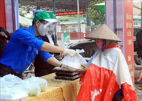 Xuất ăn miễn phí làm ấm lòng người lao động nghèo giữa mùa dịch. Ảnh: An Đăng/TTXVN