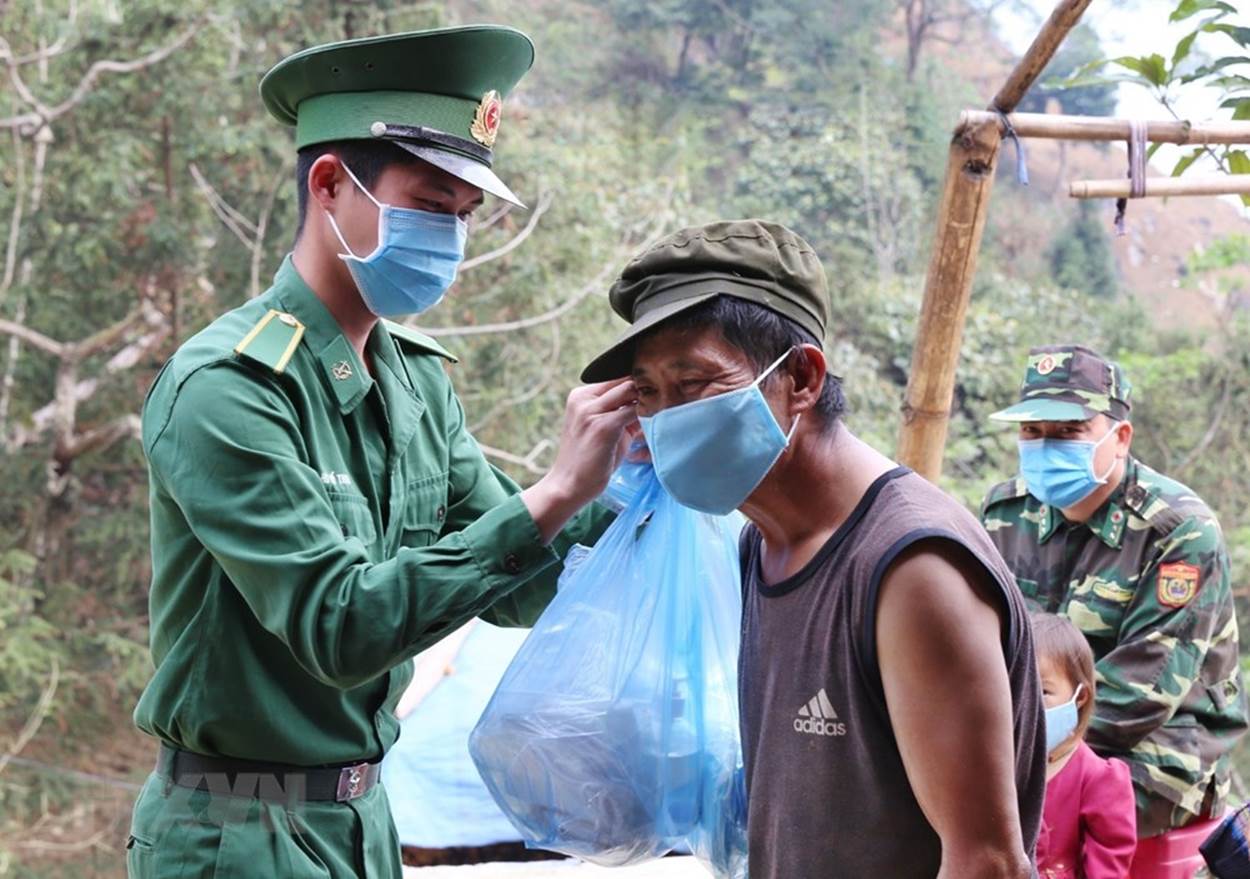  Cán bộ, chiến sỹ Đồn Biên phòng Pha Long, Bộ đội Biên phòng Lào Cai phát và hướng dẫn sử dụng khẩu trang phòng dịch cho người dân địa phương. (Ảnh: Dương Giang/TTXVN)