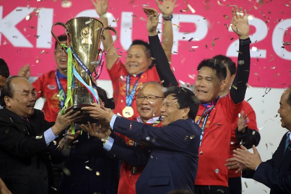 Thủ tướng Nguyễn Xuân Phúc (trái) và HLV Park Hang Seo nâng Cúp vô địch AFF Cup 2018 - Ảnh: N.K