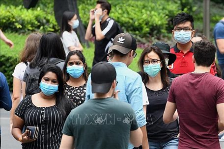 Người dân đeo khẩu trang phòng lây nhiễm COVID-19 tại Singapore ngày 5/4/2020. Ảnh: AFP/TTXVN