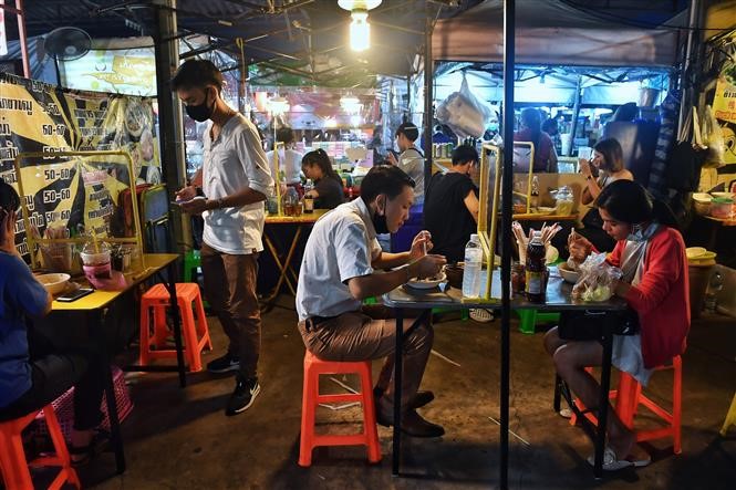 Một quán ăn tại Bangkok, Thái Lan, sử dụng tấm chắn nhựa trên bàn ăn để ngăn chặn sự lây lan của COVID-19, ngày 22/5/2020. Ảnh: AFP/ TTXVN