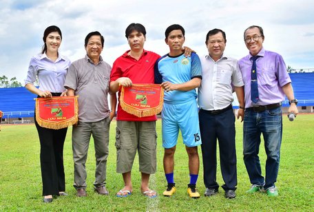 Ông Nguyễn Hữu Khánh- Tổng Biên tập Báo Vĩnh Long (thứ hai, bên trái) cùng BTC trao cờ lưu niệm cho anh Trần Thanh Trường (áo đỏ).