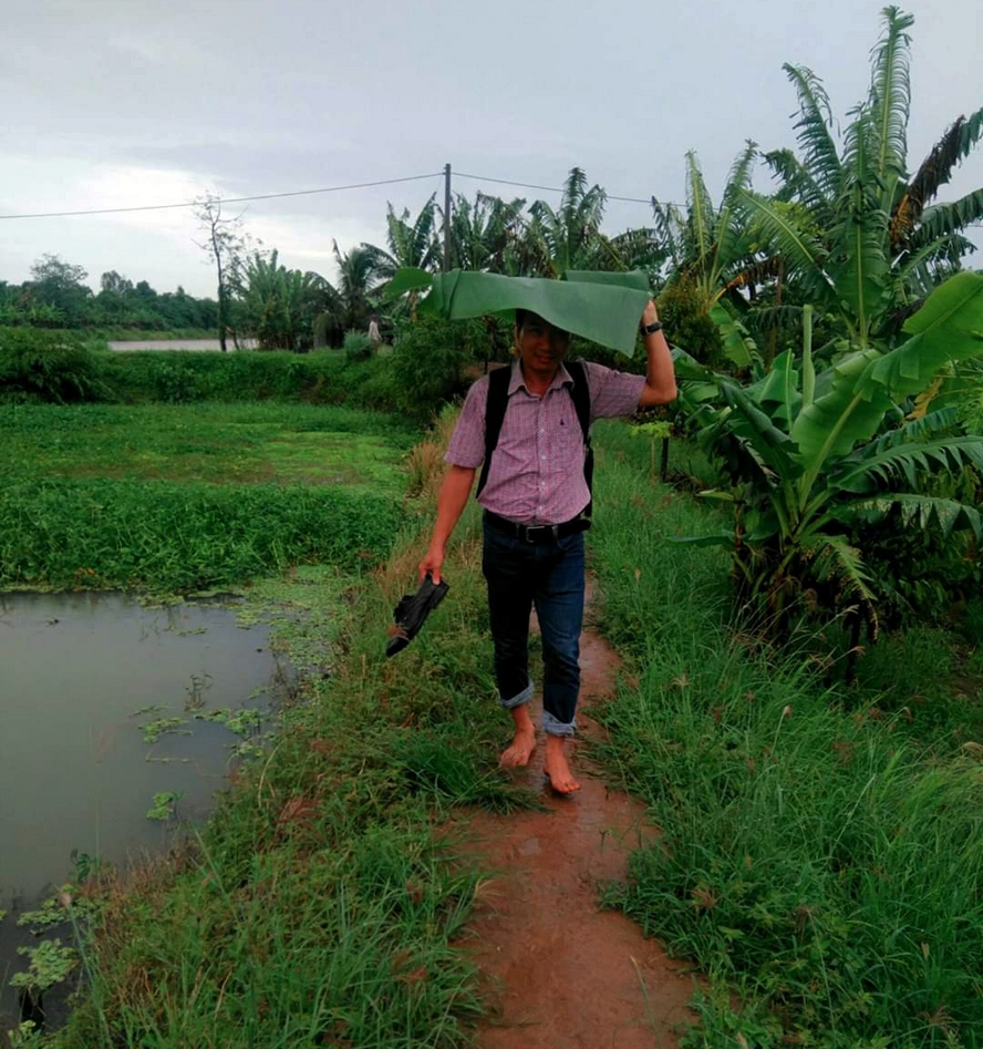 “Che mưa bằng dù… cây nhà lá vườn”, nhà báo Trần Phước (Báo Vĩnh Long) trên đường đi công tác tại Cồn Sơn (Quận Bình Thủy- TP Cần Thơ). Sau khi phỏng vấn xong, xế chiều thì trời mưa bất chợt. Mưa lớn kéo dài, phóng viên xắn quần, tháo giày, ngắt vội lá chuối ven đường để che mưa để kịp phà về “đất liền”.