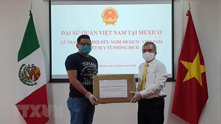 Đại sứ Việt Nam tại Mexico Nguyễn Hoài Dương (phải) trao tặng thiết bị y tế phòng dịch cho đại diện Viện Hữu nghị Mexico Việt Nam. (Ảnh: Lưu Việt Hùng/TTXVN)