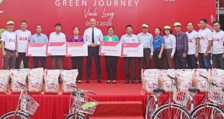 Ông Wayne Besant- Tổng Giám đốc AIA Việt Nam (giữa) trao biểu trưng đến các trường học và đại diện địa phương.