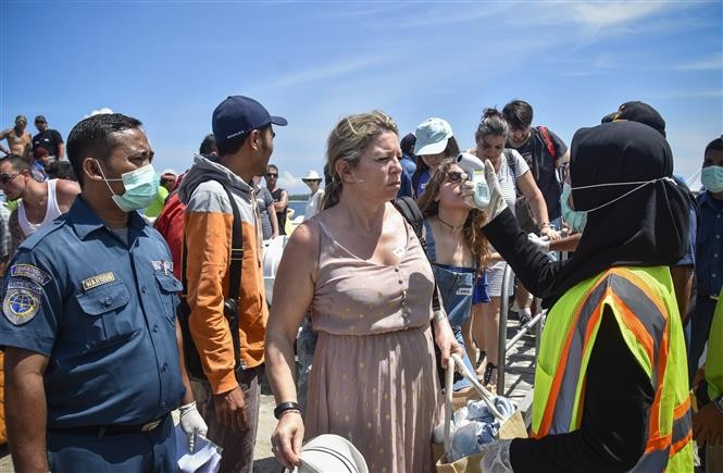  Nhân viên y tế kiểm tra thân nhiệt cho du khách tại Bali, Indonesia, ngày 12/2/2020. Ảnh: AFP/ TTXVN