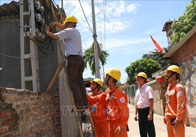 Đại diện Tổng cục Tiêu chuẩn Đo lường Chất lượng kiểm tra chì niêm phong công tơ khách hàng sử dụng điện tại Công ty Điện lực Mê Linh (Hà Nội). Ảnh: Ngọc Hà/TTXVN