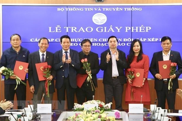 Phó trưởng Ban Tuyên giáo Trung ương Lê Mạnh Hùng và Thứ trưởng Bộ Thông tin và Truyền thông Hoàng Vĩnh Bảo trao giấy phép cho 18 tạp chí thực hiện chuyển đổi, sắp xếp lại theo quy hoạch báo chí. (Ảnh: Minh Quyết/TTXVN)