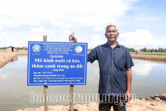 Ông Kim Chặy bên ao mô hình nuôi cá kèo thâm canh trong ao đất. Ảnh: THÚY LIỄU