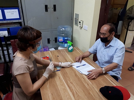 Phát tiền hỗ trợ người có công đang hưởng trợ cấp tháng tại phường Ô Chợ Dừa (Đống Đa, Hà Nội).