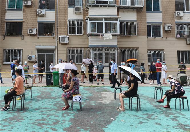Người dân xếp hàng chờ lấy mẫu xét nghiệm COVID-19 tại một điểm xét nghiệm dã chiến ở thành phố Đại Liên, tỉnh Liêu Ninh, Trung Quốc ngày 28/7/2020. Ảnh: AFP/TTXVN
