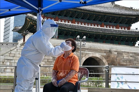 Nhân viên y tế lấy mẫu xét nghiệm COVID-19 cho người dân tại Seoul, Hàn Quốc ngày 10/8. Ảnh: AFP/TTXVN