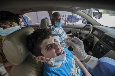 Nhân viên y tế lấy mẫu xét nghiệm COVID-19 tại Cairo, Ai Cập. Ảnh: AFP/TTXVN