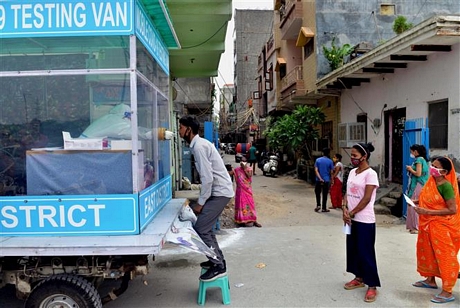   Nhân viên y tế lấy mẫu dịch xét nghiệm COVID-19 cho người dân tại Delhi, Ấn Độ, ngày 4/8/2020. Ảnh: THX/ TTXVN
