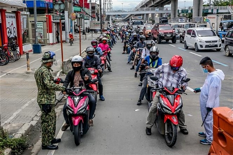 Kiểm tra thân nhiệt phòng dịch COVID-19 tại Philippines. Ảnh: AFP