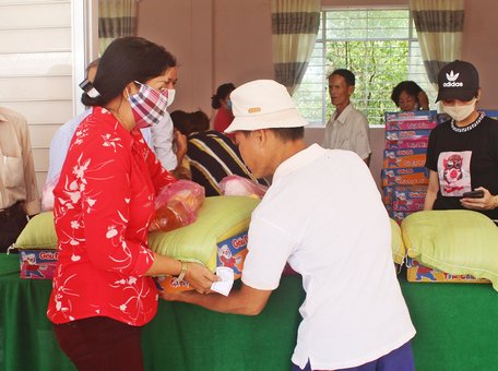 Chính quyền địa phương cùng các đơn vị, nhà hảo tâm trao quà cho hộ nghèo.