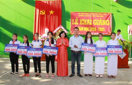 Bà Nguyễn Thị Minh Hạnh- Ủy viên Thường vụ Tỉnh ủy, Trưởng Ban Dân vận Tỉnh ủy và đại diện nhà tài trợ Mobifone Vĩnh Long trao học bổng cho học sinh giỏi đầu cấp.