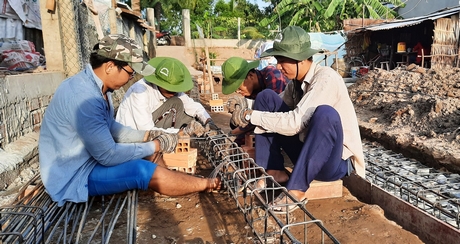 Sinh viên Trường ĐH Xây dựng Miền Tây hỗ trợ xây nhà cho người dân.