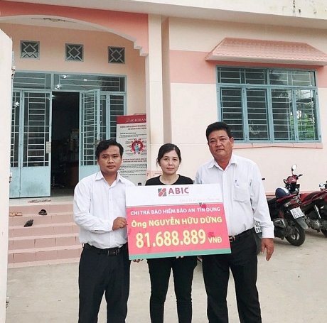Đại diện Agribank Phòng Giao dịch Thanh Bình và ABIC Cần Thơ- Phòng Kinh doanh khu vực Vĩnh Long trao biểu trưng chi trả bảo hiểm cho gia đình khách hàng.