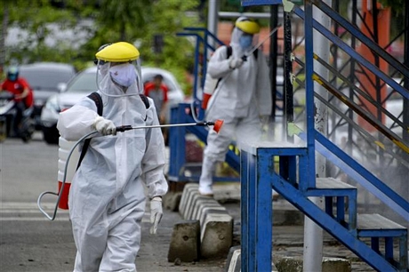 Phun thuốc diệt trùng virus gây dịch COVID-19 tại Indonesia. Ảnh: AFP