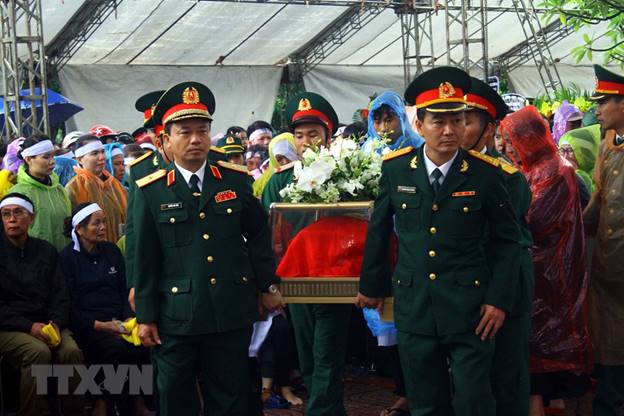  Di chuyển hài cốt để án táng các liệt sỹ tại Nghĩa trang Liệt sỹ thành phố Vinh. (Ảnh: Tá Chuyên/TTXVN)