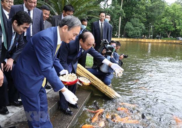 Thủ tướng Nguyễn Xuân Phúc và Thủ tướng Nhật Bản Suga Yoshihide bên Ao cá Bác Hồ trong Khu Di tích Chủ tịch Hồ Chí Minh tại Phủ Chủ tịch. (Ảnh: Lâm Khánh/TTXVN)