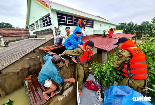 Trung úy Trần Công Hoàng Trung (Công an huyện Lệ Thủy) cõng người dân thoát lũ chiều 19/10 - Ảnh: NGỌC HIỂN