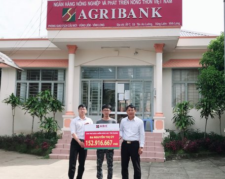 Đại diện Agribank Phòng Giao dịch Cầu Mới và ABIC Cần Thơ- Phòng Kinh doanh khu vực Vĩnh Long trao biểu trưng chi trả bảo hiểm cho gia đình khách hàng.