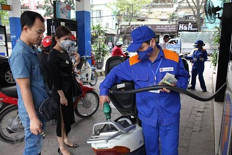 Nhân viên Petrolimex đang bán xăng cho khách hàng. (Ảnh: Đức Duy/Vietnam+)