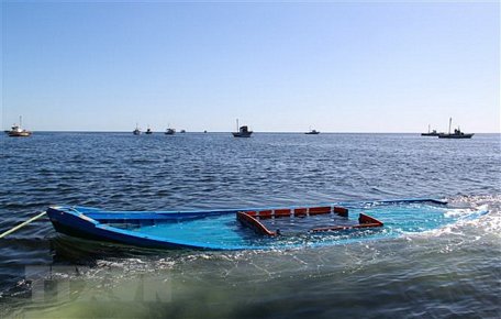 Một chiếc thuyền chở người di cư bị đắm ở ngoài biển. (Ảnh: AFP/TTXVN)