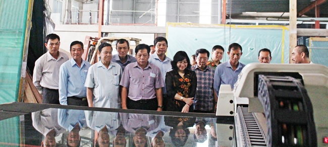 Đoàn tham quan một quy trình cắt kính tại công ty TNHH MTV Thương mại và Dịch Vụ Nguyên Thành.