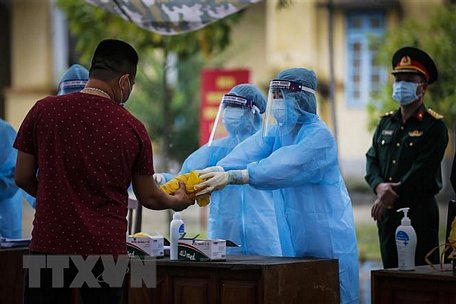 Các công dân nhận đồ dùng cá nhân cùng phương diện phòng chống dịch tại khu cách ly tập trung. (Ảnh: Trọng Đạt/TTXVN)