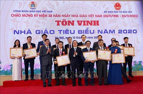 Bộ trưởng Bộ Giáo dục và Đào tạo Phùng Xuân Nhạ và Chủ tịch Công đoàn giáo dục Việt Nam Vũ Minh Đức trao Bằng khen cho các nhà giáo tiêu biểu. Ảnh: Hoàng Hiếu/TTXVN