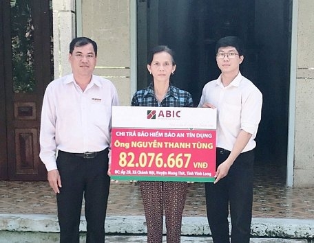 Đại diện Agribank huyện Mang Thít và ABIC Cần Thơ- Phòng Kinh doanh khu vực Vĩnh Long trao biểu trưng cho gia đình khách hàng. 