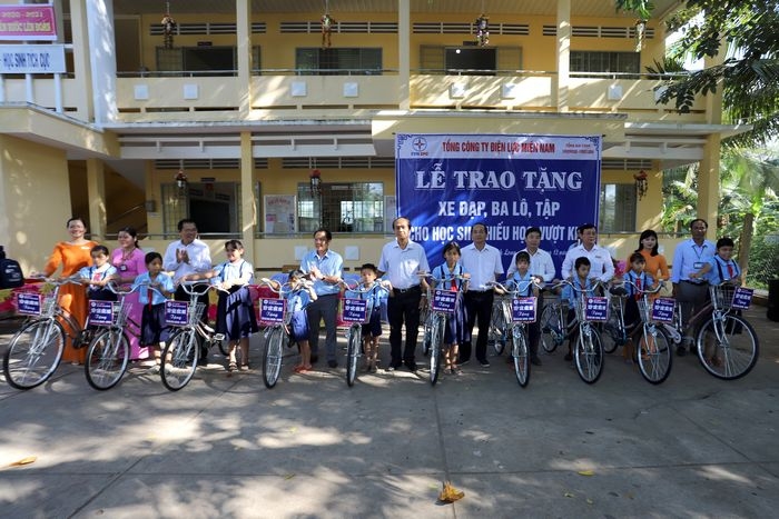 Ông Phạm Ngọc Lễ- Phó Tổng Giám đốc Tổng Công ty Điện lực Miền Nam (thứ 6 từ phải sang) trao xe đạp cho học sinh Trường Tiểu học Thới Hòa B.