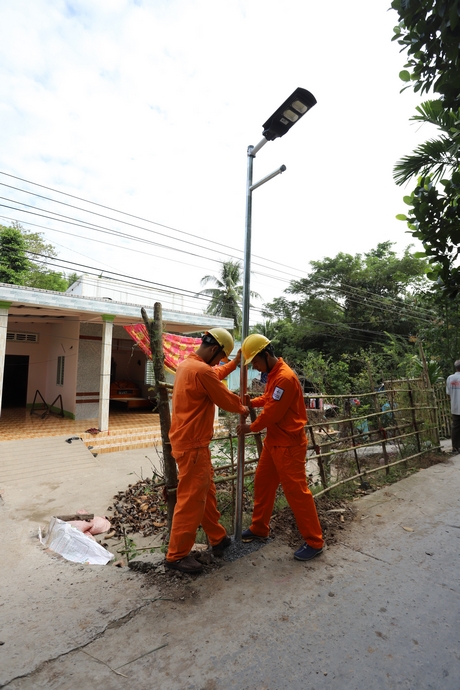 Công nhân điện lực lắp trụ đèn.