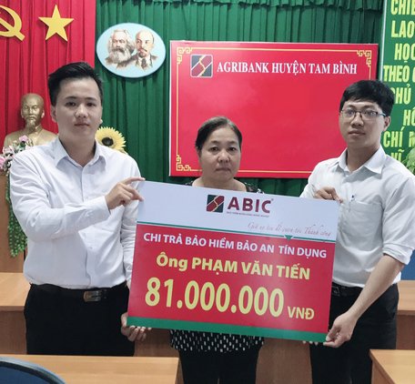 Đại diện Agribank huyện Tam Bình và ABIC Cần Thơ- Phòng Kinh doanh khu vực Vĩnh Long trao biểu trưng chi trả bảo hiểm cho gia đình khách hàng.