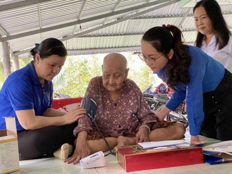 Mẹ Việt Nam anh hùng Trương Thị Hai (101 tuổi, xã An Bình- Long Hồ) vui mừng khi nhận được chiếc máy đo huyết áp.