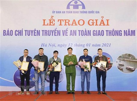 Thiếu tướng Nguyễn Duy Ngọc, Thứ trưởng Bộ Công an, Phó Chủ tịch Ủy ban An toàn giao thông Quốc gia trao giải Nhì cho các tác giả. (Ảnh: Doãn Tấn/TTXVN)